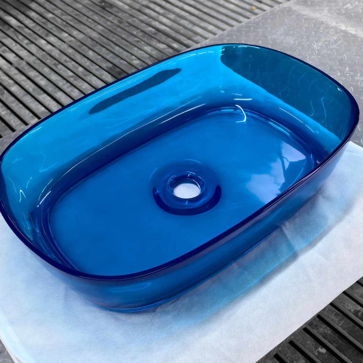 Blue glass basin on a textured surface