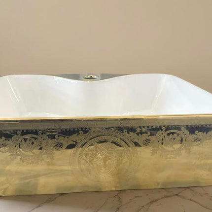 Rechteckiges, weiß-goldenes Waschbecken mit ikonischem Medusa-Motiv