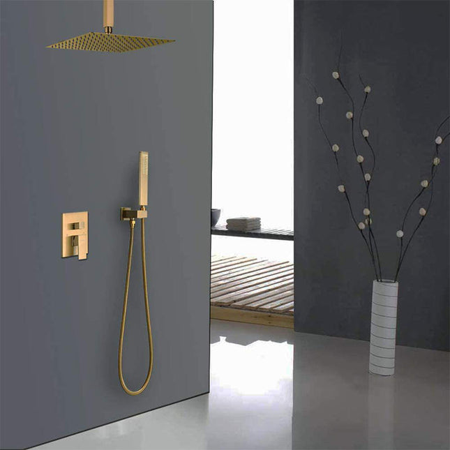 Gold shower head and control panel mounted on a gray wall with a vase and plant in the background.