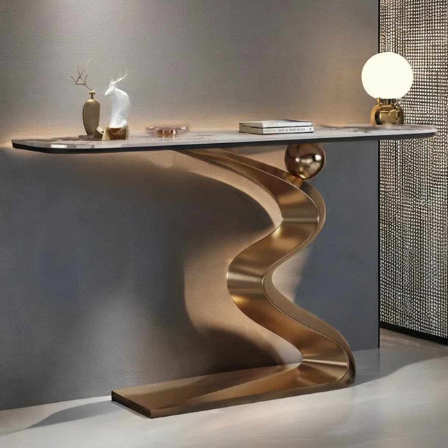 Modern console table with wavy brass base against a gray wall