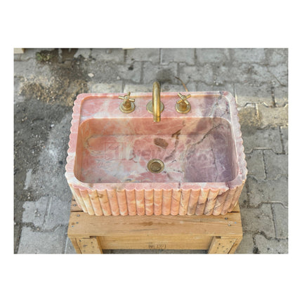 Lavabo mural en marbre rose naturel pour salle de bain, avec lave-mains intégré.