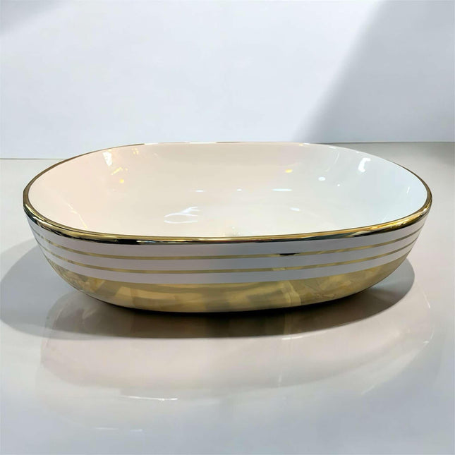 Oval Tabletop Wash Basin with Pristine White Interior Gleaming Gold Base and Refined Gold Striped Accents