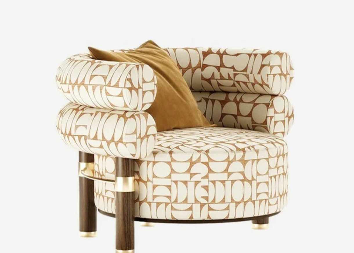 Sculptural Armchair with Geometric Patterned Upholstery, Cylindrical Cushions, and Contrasting Dark Legs with Brass Accents