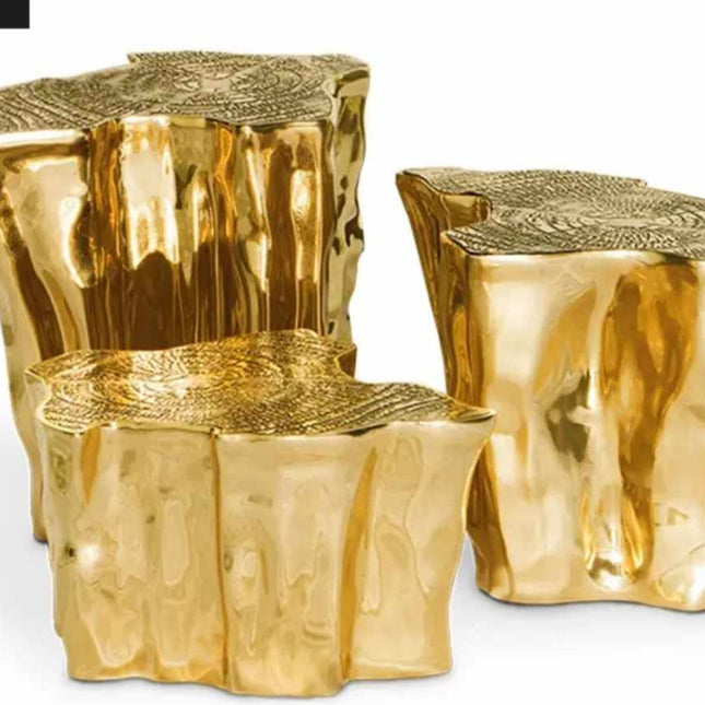 Gold tree stump tables with Leon Home logo in the corner