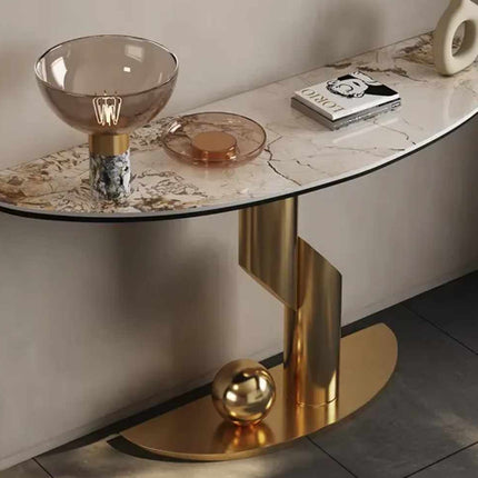 Modern console table with marble top and gold base in a room setting.