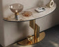 Modern console table with marble top and gold base in a room setting.