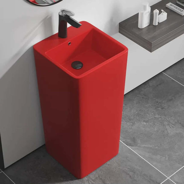 Red freestanding sink in a bathroom setting with a gray floor.