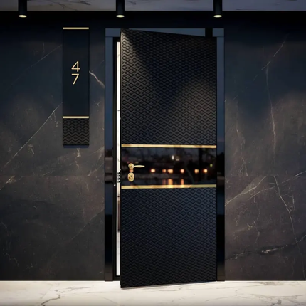 Luxury black door with gold accents on a dark marble wall