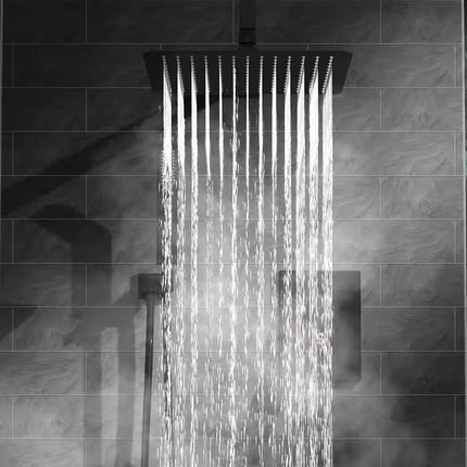 Square shower head with water droplets on a tiled wall