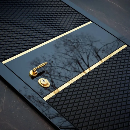 Close-up of a black door with gold handle and lock, reflecting trees.