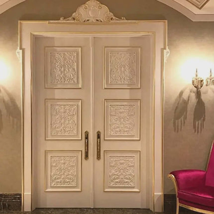 Decorative double door with intricate carvings in a room with a pink chair.