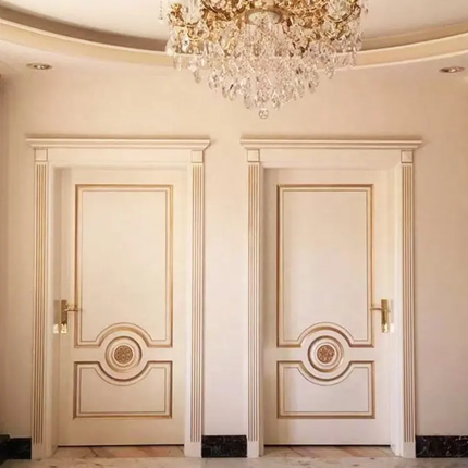 Two ornate doors with gold accents in a luxurious room with a chandelier.