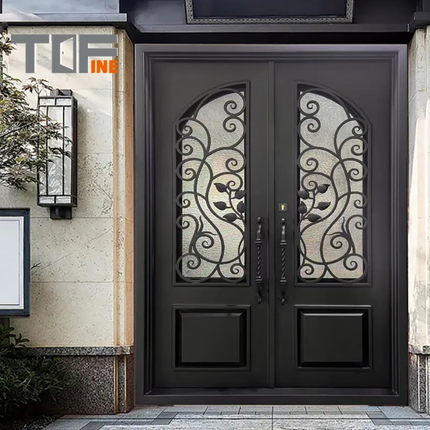 Decorative black double door with intricate designs on a building facade.