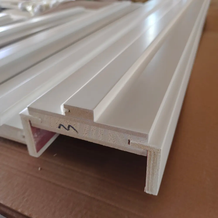 Close-up of a white plastic profile with a brand logo on a brown surface