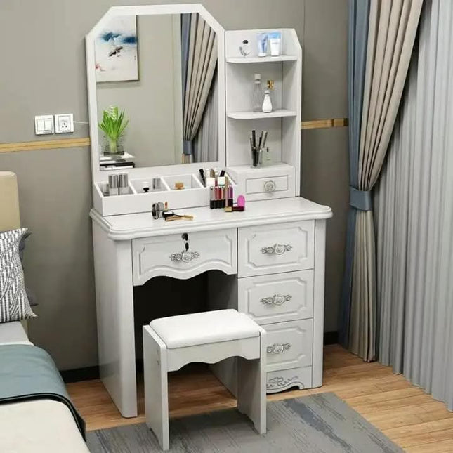 White vanity table with mirror and stool in a bedroom setting