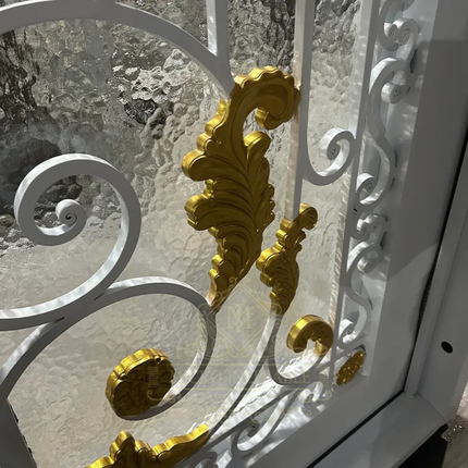 Decorative metal gate with gold accents and glass panels