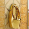 Gold-colored urinal mounted on a tiled wall.