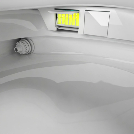 Close-up of a white appliance interior with a yellow light indicator.