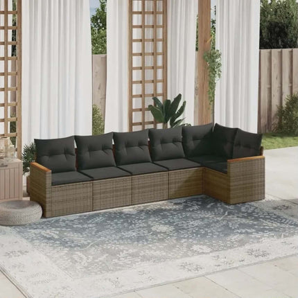 Outdoor patio sectional with dark cushions on a patio with curtains and plants in the background.