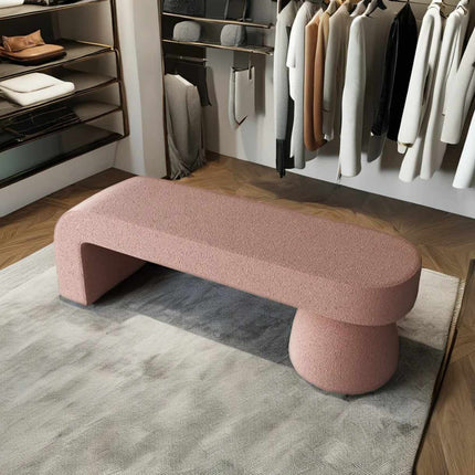 Pink bench in a room with clothing racks and shelves.