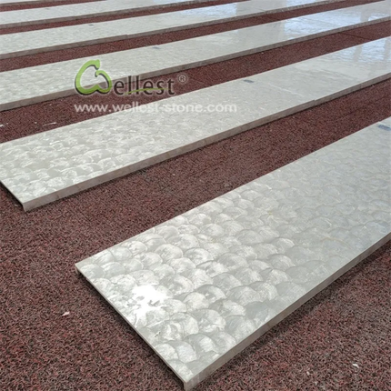 Close-up of stone tiles with a brand logo in the corner