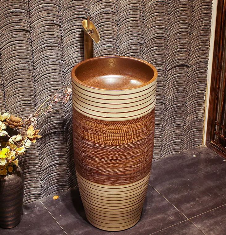 Standalone pedestal sink in brown porcelain with a smooth, glossy finish and minimalist design