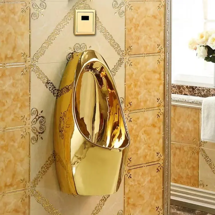 Gold urinal mounted on a decorative wall with ornate patterns