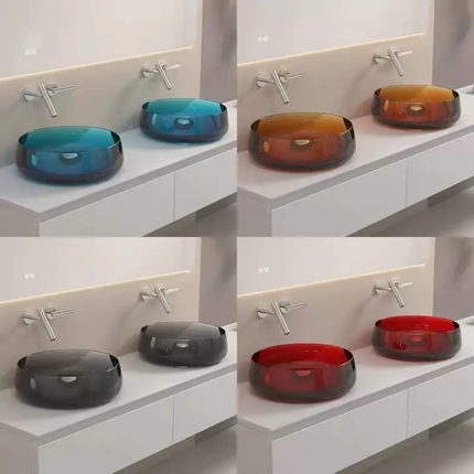 Four different colored glass sinks on a white countertop.