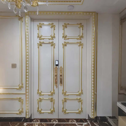 Decorative white door with gold molding in a luxurious interior setting.