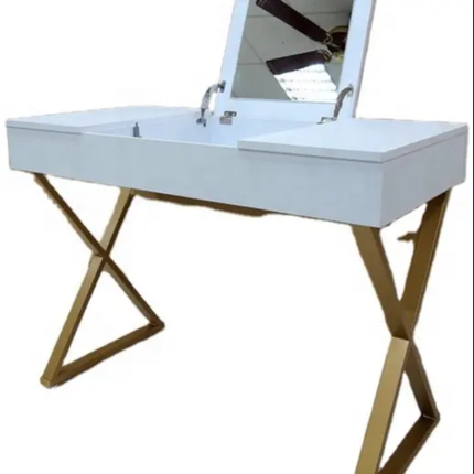 A modern vanity desk with a white rectangular top, gold-tone X-shaped metal legs, and an integrated mirror on a white background.