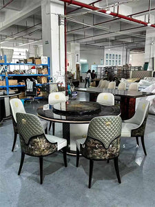 Luxurious Round Dining Table Stainless Steel Set with Black Marble Top, Elegant Quilted Leather and Wood-Inlaid Chairs, and Gold Embellishments in a High-End Furniture