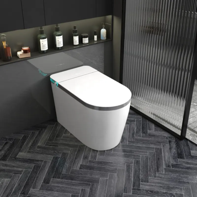 Modern white toilet in a stylish bathroom with dark tiles and minimal decor.