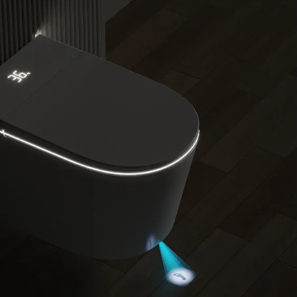 Modern black toilet with illuminated seat and floor in a dark bathroom setting