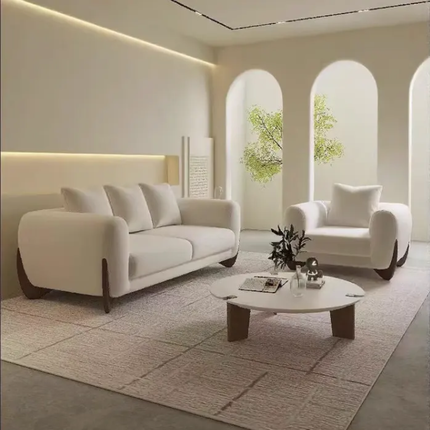 Modern living room with white sofa, armchair, and coffee table in a neutral color scheme.