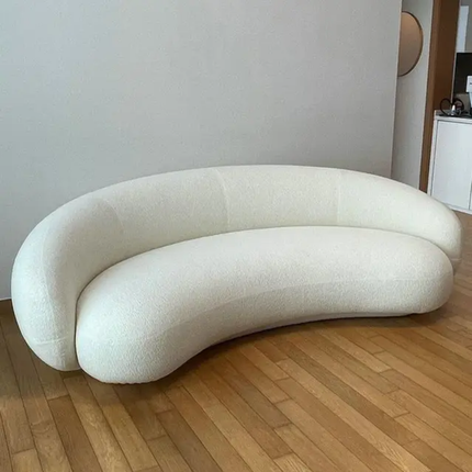 Modern white sofa on a wooden floor with a neutral wall background