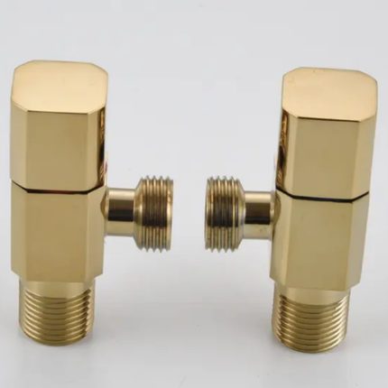 Two gold-colored plumbing valves on a white background