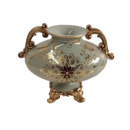 Decorative vase with gold floral patterns and bronze handles on a white background