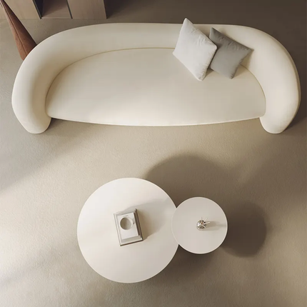 Modern white sofa with two cushions and a matching side table on a neutral background