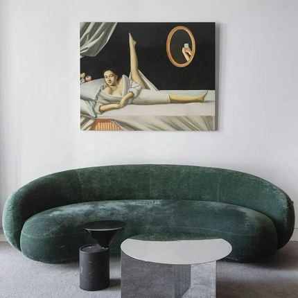 Modern living room with a green sofa, black and white side tables, and a painting on the wall.