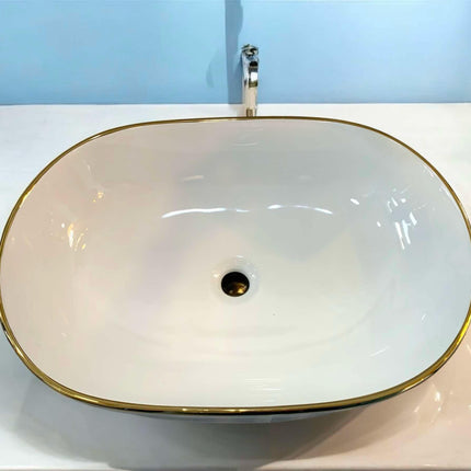 Oval Tabletop Wash Basin with Pristine White Interior Gleaming Gold Base and Refined Gold Striped Accents