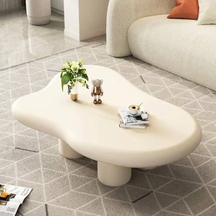 Modern white coffee table with decorative items in a living room setting