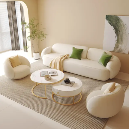 Modern living room with white sofa, armchairs, and coffee table.