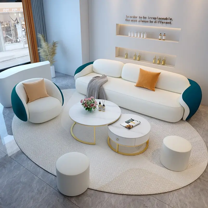 Modern living room with white sofa, armchair, and coffee table.