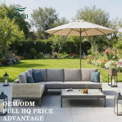 Outdoor patio set with sectional sofa, coffee table, and umbrella in a garden setting.