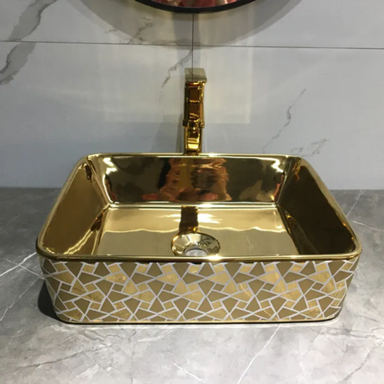 Gold rectangular sink with geometric pattern on a marble countertop