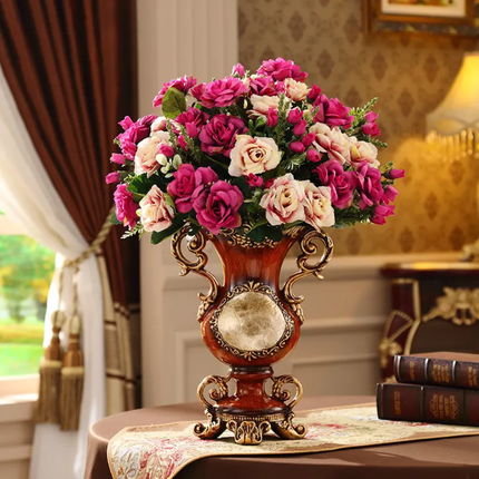 Decorative vase with pink and white flowers on a table in a room setting.