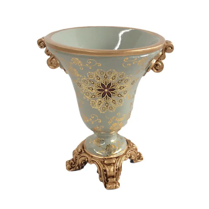 Decorative vase with gold floral patterns on a light blue background