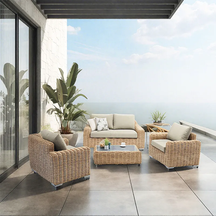 Outdoor patio set with wicker furniture and cushions on a modern patio.