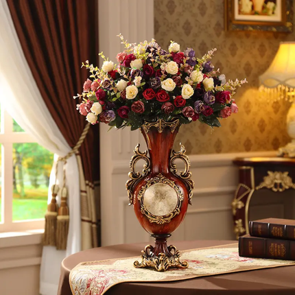 Decorative vase with flowers on a table in a room with a window and lamp.