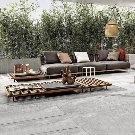 Outdoor patio with modern sofa set and coffee table on a tiled floor.
